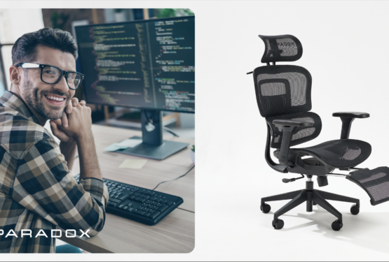 A smiling man in glasses sits at a desk with a computer, next to a sleek black Paradox ergonomic chair.