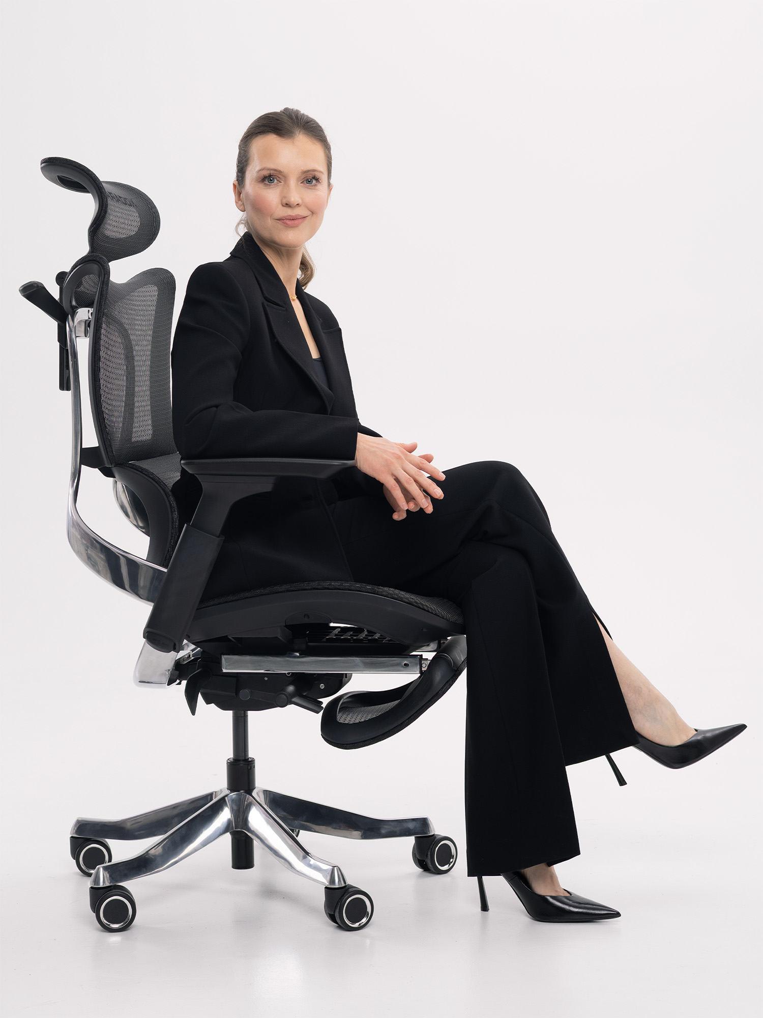 Woman in Paradox Ergo Milano Pro Black — demonstrating 4D armrest positioning